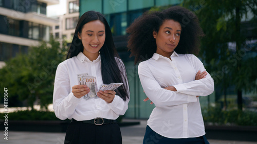 Asian Korean African American women count money salary bonus income envy arms crossed females inequality business financial colleague rivalry jealousy cash pay bills discrimination girls rich outdoors