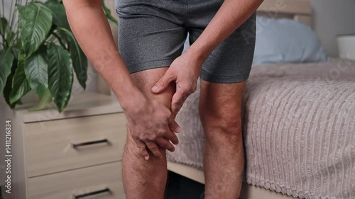 Close-up of legs, man massaging and stretching his knees with arthritis and fibromyalgia symptoms. health concept sports doctors