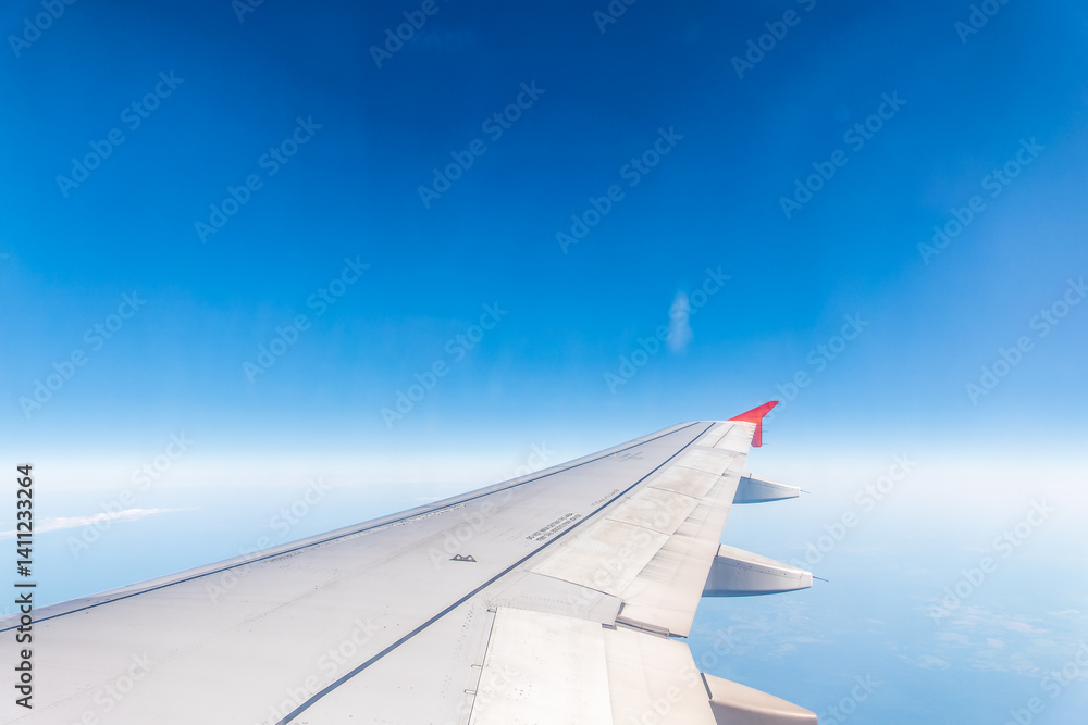 View from the airplane window at a beautiful cloudy sky and the airplane wing View from the airplane window at a beautiful cloudy sky and the airplane wing
