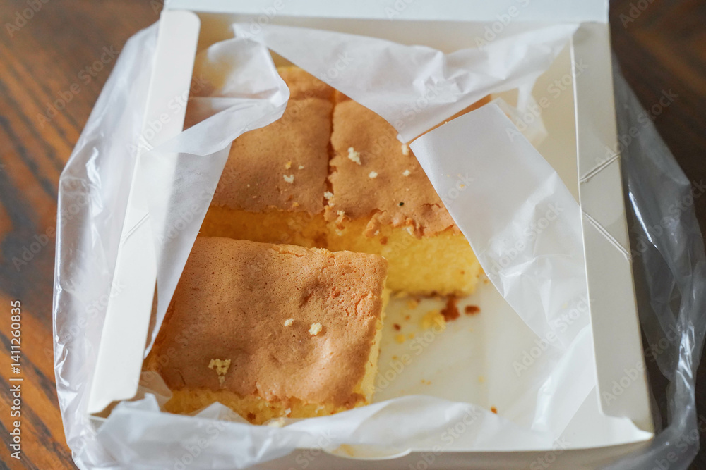 three pieces of cake in takeout box on table
