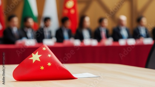 Obraz na płótnie Global Collaboration and Diversity in an Interconnected World, A Chinese flag sits on a table at a formal event with attendees in suits blurred in the background. w salonie