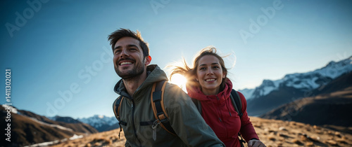 Hikers couple walking in the mountains at sunset, enjoying the view