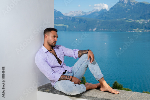 Obraz na płótnie Hispanic sexy man on mountain Alps landscape. A handsome tourist man on alpine lake. A strong, sexy man posing in summer nature. A dreamy, carefree traveler. Man freedom in the outdoors. w salonie