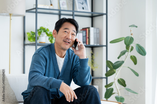 Papier peint リビングで電話するミドルの男性