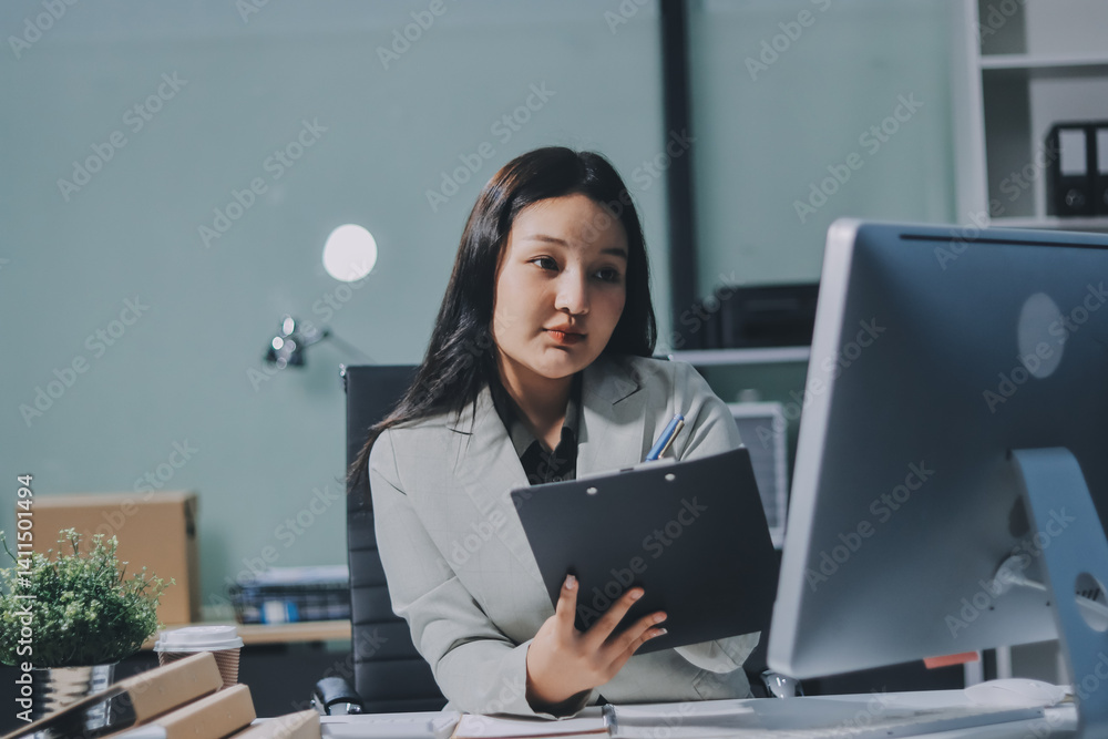 Asian Businesswoman Using laptop computer and working at office with calculator document on desk, doing planning analyzing the financial report, business plan investment, finance analysis concept. Asian Businesswoman Using laptop computer and working at office with calculator document on desk, doing planning analyzing the financial report, business plan investment, finance analysis concept.