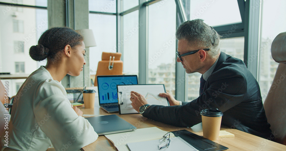 Fototapeta premium Businessman showing financial chart to colleague