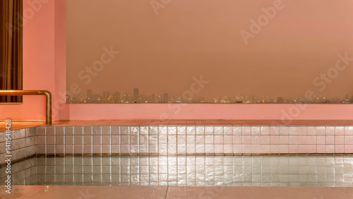 Modern rooftop infinity pool with silver tiled lining overlooking city skyline at dusk