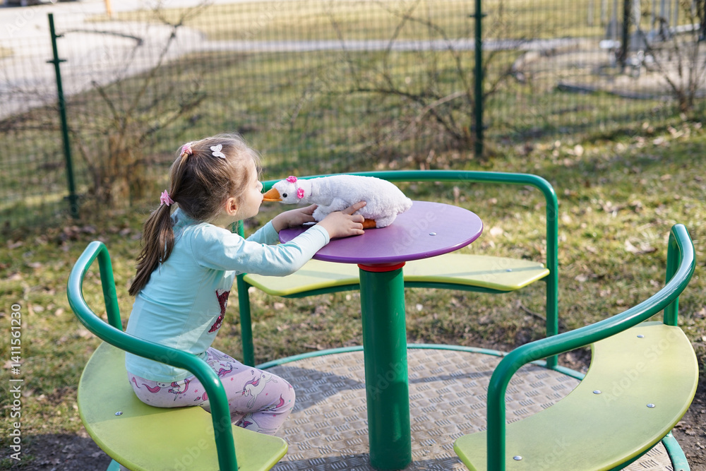 Fototapeta premium Girl Kissing Toy Duck at Playground