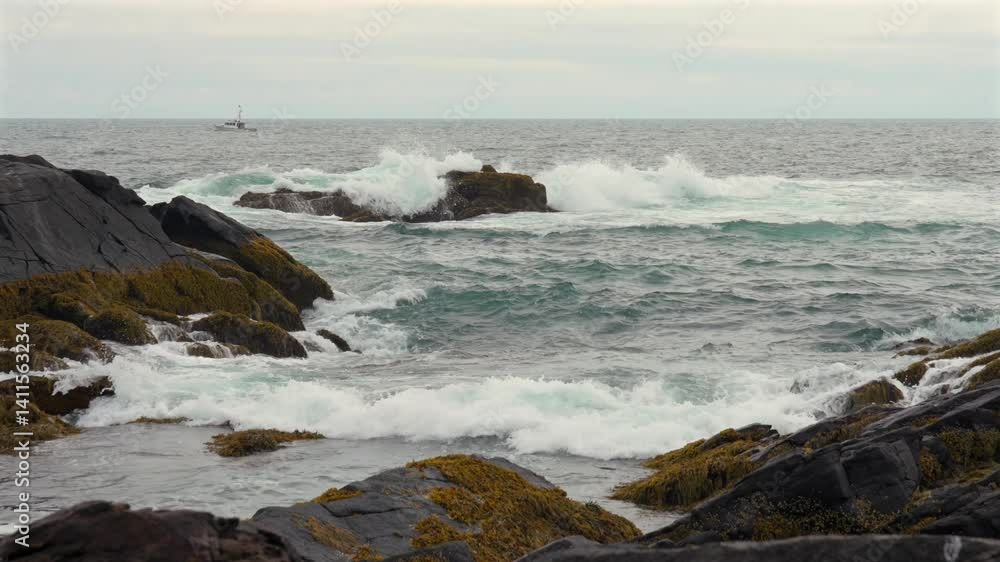 A high angle view of the ocean waves on the rocky shore along the coast of Maine with a fishing trawler in the distance. A high angle view of the ocean waves on the rocky shore along the coast of Maine with a fishing trawler in the distance.