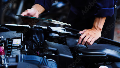 Fotografie Auto mechanic hands using wrench to repair auto engine