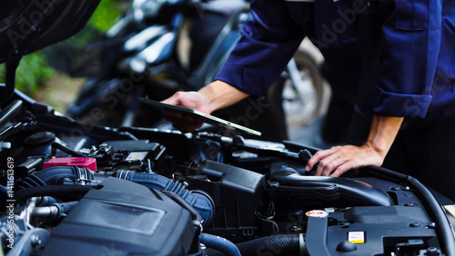 Auto mechanic hands using wrench to repair auto engine. Car maintenance, service at garage. Technician inspects vehicle for problems. Auto repair, fixing, check, services, insurance, checkup concept.