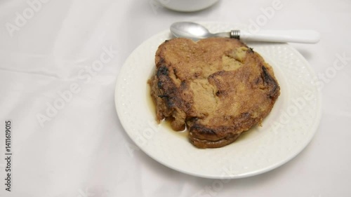 Slow-motion closeup pan of toronjas - sweet wine-soaked Easter Week bread with glistening raisins in soft light.