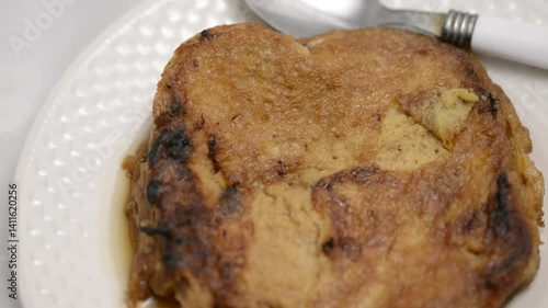 Slow-motion closeup pan of toronjas - sweet wine-soaked Easter Week bread with glistening raisins in soft light.