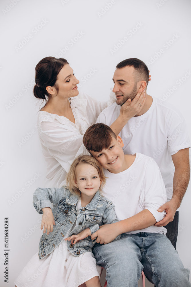 The family is beautiful and happy, mother, father, son and daughter together portrait on a white background The family is beautiful and happy, mother, father, son and daughter together portrait on a white background