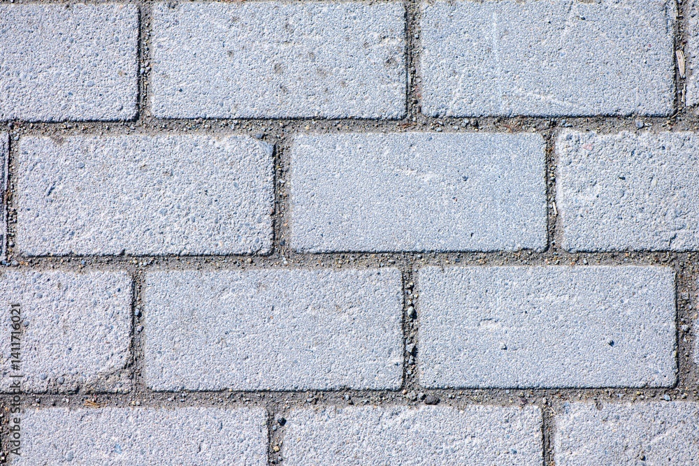 Interlocking gray concrete brick pavers forming a solid, textured pavement surface, providing versatility for various outdoor applications like walkways, patios, and driveways Interlocking gray concrete brick pavers forming a solid, textured pavement surface, providing versatility for various outdoor applications like walkways, patios, and driveways