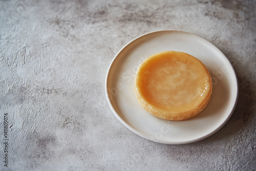 Delicious small caramel custard tart on a plate simple dessert