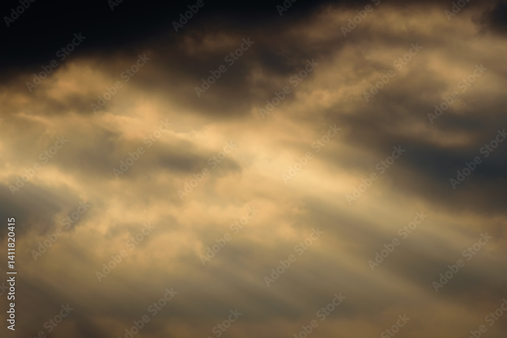 dark dramatic sky at sunset with sun rays through the clouds