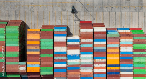 Rows of colorful shipping containers at a busy port during daylight