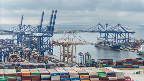 Industrial shipping terminal bustling with activity during overcast weather near a coastal city - Perama, Greece
