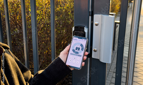 Obraz na płótnie Young stylish woman getting access to the building by attaching smartphone to intercom. Concept of modern security technologies for access and smart home w salonie