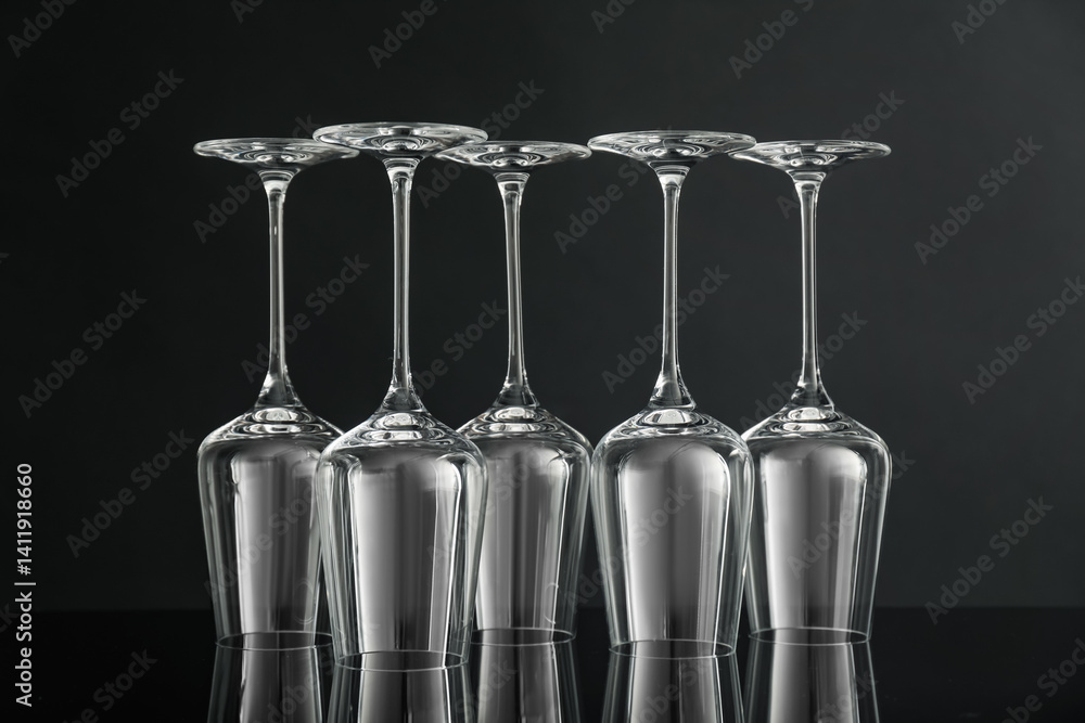 Many empty clean glasses on mirror surface against black background Many empty clean glasses on mirror surface against black background