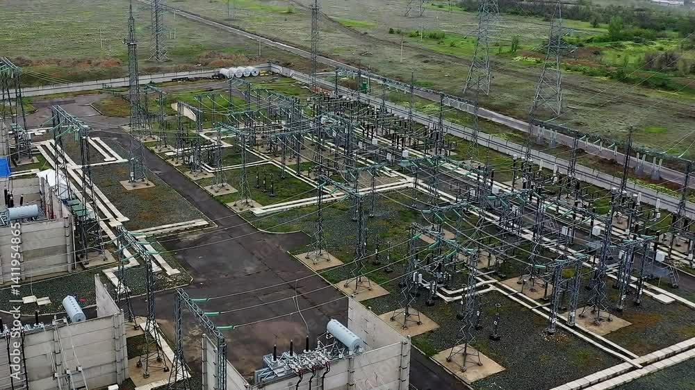 Bird's-eye view of a power transmission substation with equipment and overhead power lines Bird's-eye view of a power transmission substation with equipment and overhead power lines