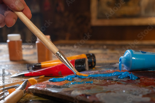 Artist s hands with brushes mixing colors