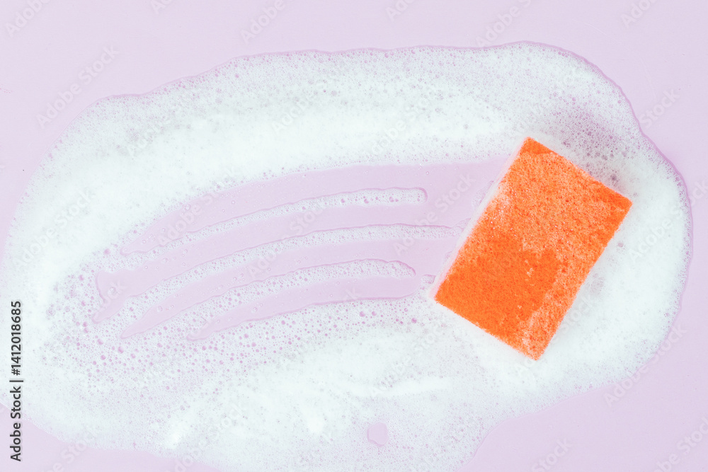 A sink full of soapy water with a sponge on top