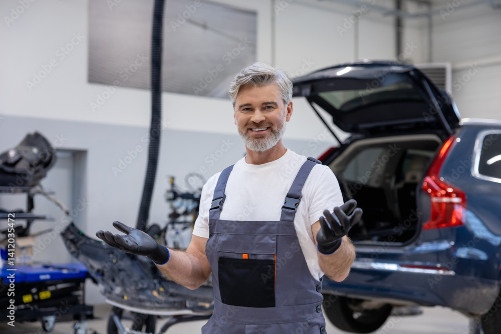 Man in uniform working indoors in garage Man in uniform working indoors in garage