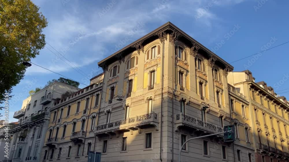 A charming residential corner building in Milan, featuring elegant architecture, vibrant balconies adorned with flowers, and a lively street atmosphere. Perfect for capturing the essence of city life. A charming residential corner building in Milan, featuring elegant architecture, vibrant balconies adorned with flowers, and a lively street atmosphere. Perfect for capturing the essence of city life.
