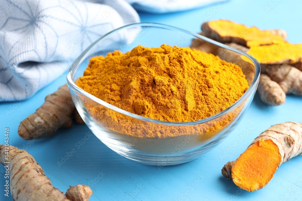 Aromatic turmeric powder in bowl and fresh roots on light blue wooden table, closeup Aromatic turmeric powder in bowl and fresh roots on light blue wooden table, closeup
