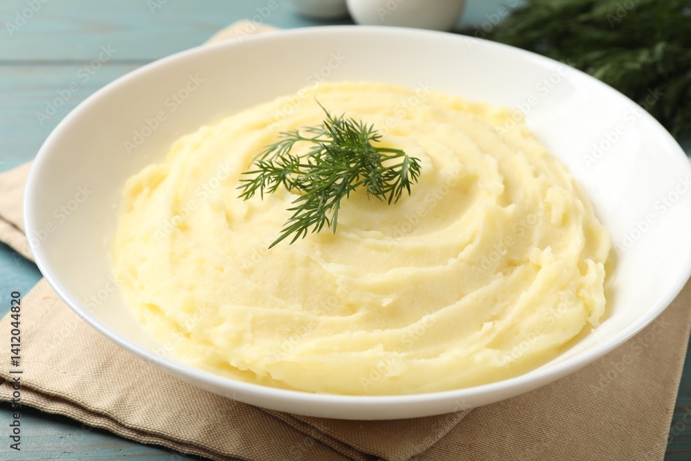 Tasty mashed potato with dill in bowl on light blue wooden table, closeup Tasty mashed potato with dill in bowl on light blue wooden table, closeup