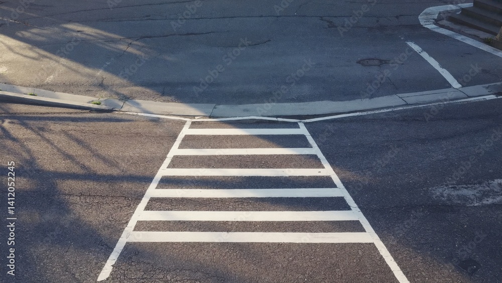 Fototapeta premium A street with a white line painted on the ground and a crosswalk