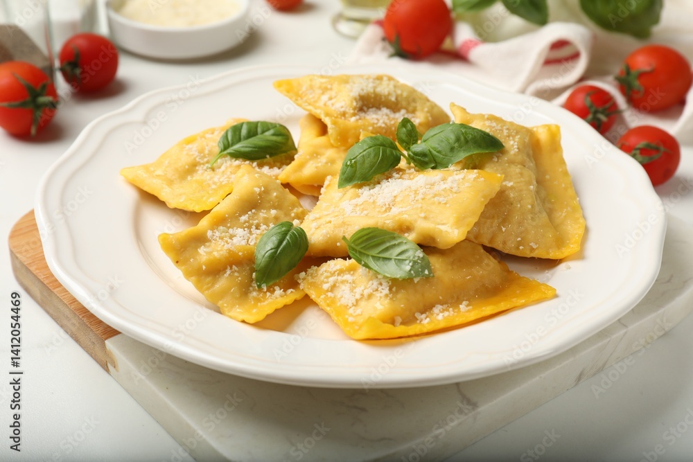 Delicious ravioli with cheese and basil served on white table, closeup Delicious ravioli with cheese and basil served on white table, closeup