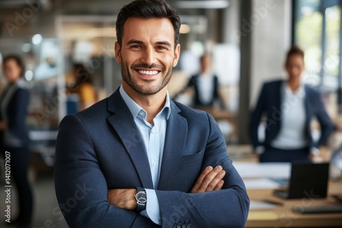 Obraz na płótnie handsome smiling businessman in a suit standing in the office w salonie