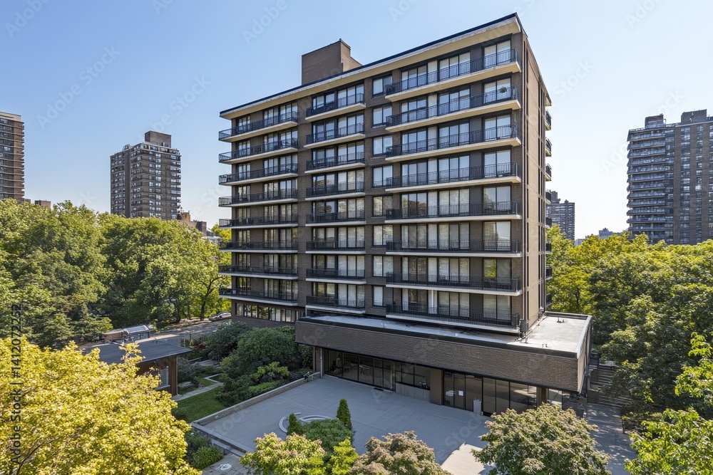 view of an old huge residential high-rise apartment building with a lot of windows and balconies