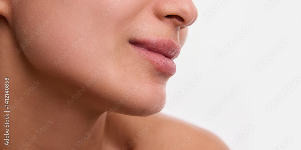 Obraz premium Cropped close-up image of beautiful female face with spotless, clear skin and plump lips isolated on white background. Face lifting effect, no double chin, perfect lower face part line