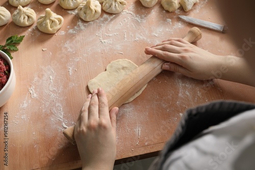 Wallpaper Mural Woman making khinkali at table in kitchen, above view Torontodigital.ca