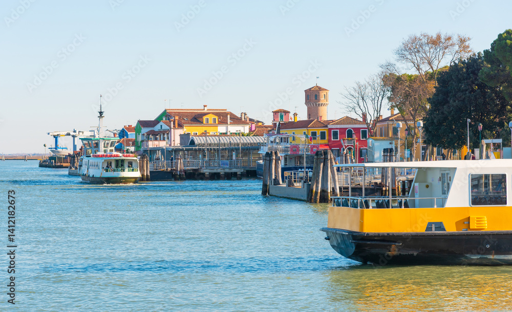 Obraz premium Ferry boats docking near colorful waterfront buildings on island
