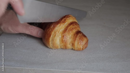 Close-Up of Knife Cutting Through Buttery Croissant
