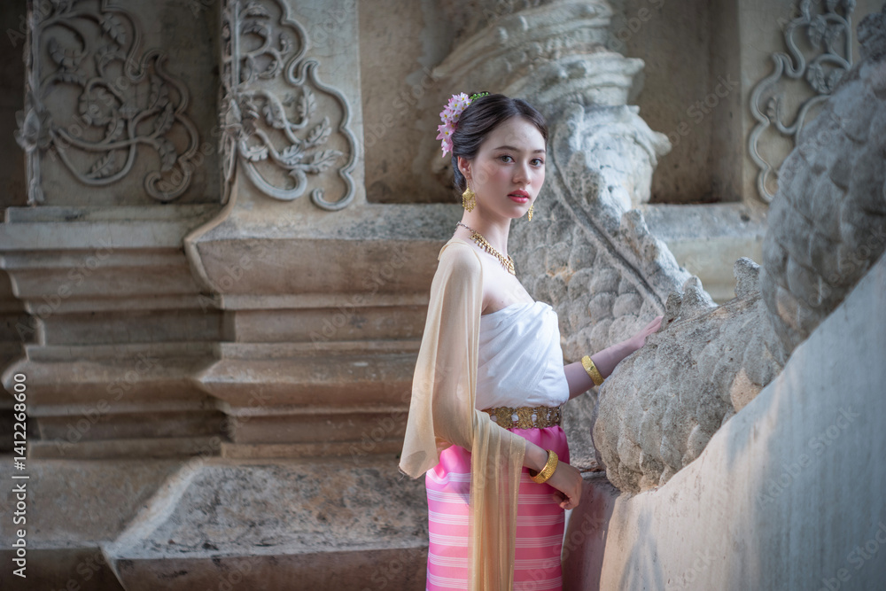 Beautiful young Asean woman in traditional Thai Dvaravati dress in an old temple in Chiang Mai, Thailand.