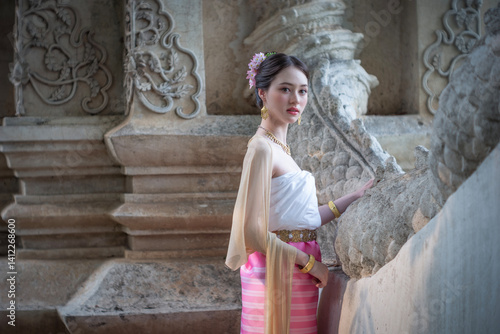 Obraz na płótnie Beautiful young Asean woman in traditional Thai Dvaravati dress in an old temple in Chiang Mai, Thailand. w salonie