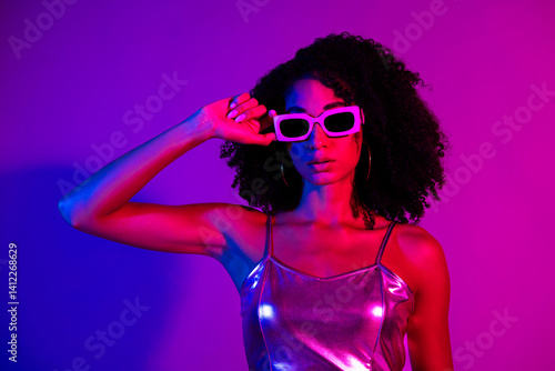 Wallpaper Mural Stylish young woman in a metallic outfit and sunglasses against vibrant neon lighting, showcasing modern fashion Torontodigital.ca
