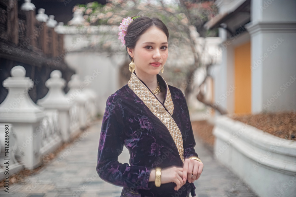 Beautiful young Asean woman in traditional Thai Dvaravati dress in an old temple in Chiang Mai, Thailand.