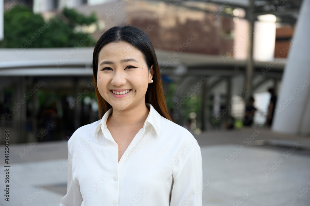 Smiling businesswoman standing in modern city setting Smiling businesswoman standing in modern city setting