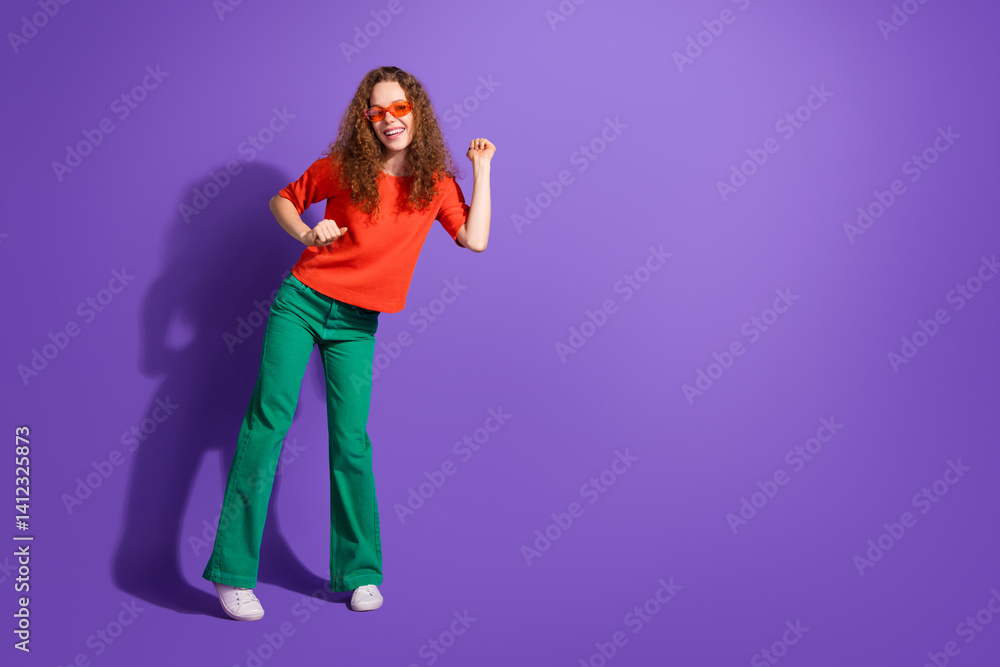 Young stylish woman in colorful outfit dancing on a purple background, expressing joy and charm in a casual fashion style Young stylish woman in colorful outfit dancing on a purple background, expressing joy and charm in a casual fashion style