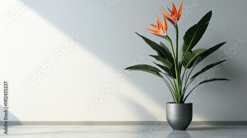A tall, modern metal vase with a single Bird of Paradise flower, minimalist style, placed against a plain white wall.