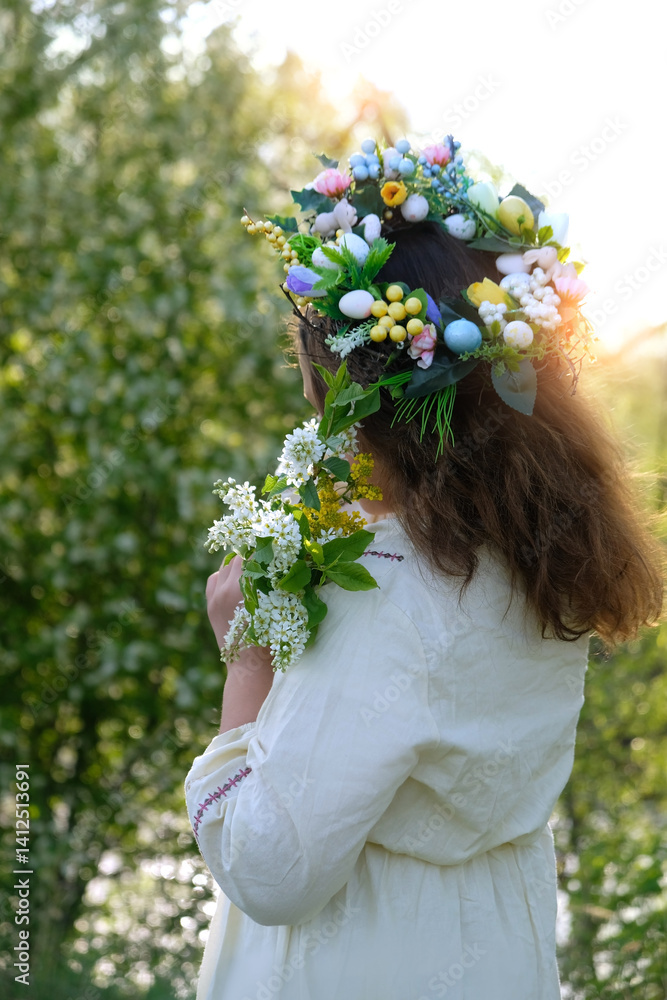 Obraz premium girl in white dress, decorative spring wreath crown with flower bouquet outdoor, nature background. rear view. concept of youth, romance, dreams, love. symbol of Easter, Ostara, spring season