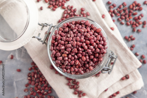 Obraz na płótnie Glass jar full of azuki beans on gray top view. Dried uncooked legumes. Vegetarian protein w salonie
