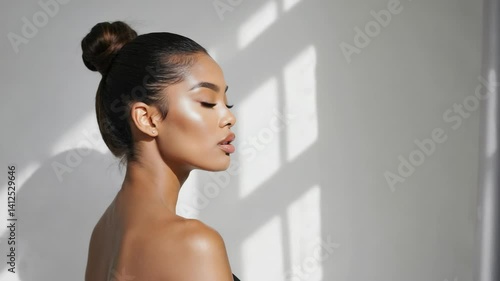 Elegant woman with glowing skin in a profile view illuminated by sunlight